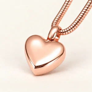 Cordiana ashanger klein hart roségoudkleurig met ketting op een crème achtergrond