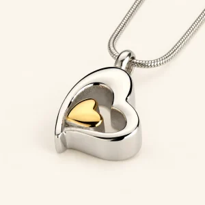 Gemella ashanger zilverkleurig hart met goudkleurig hartje met ketting op een crème achtergrond