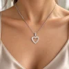 De zilverkleurige harthanger gedragen aan een fijne ketting.