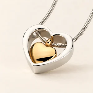 Insieme ashanger zilverkleurig hart met goudkleurig hartje met ketting op een crème achtergrond